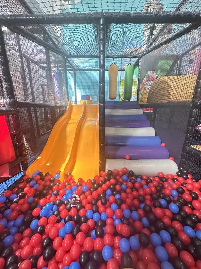 Une aire de jeux avec balles colorées.